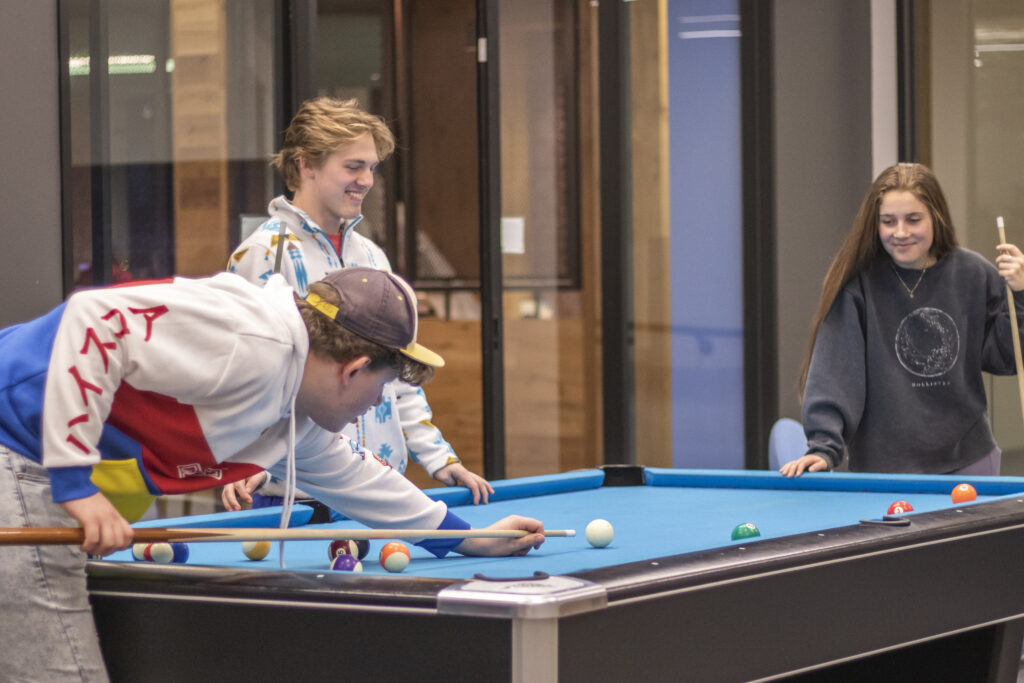 Three U N E students playing pool