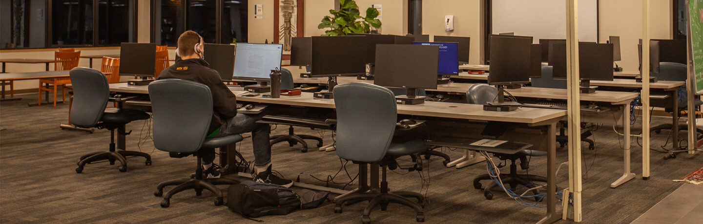 A student studies alone at night at a computer lab on the Biddeford Campus