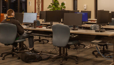 A student studies alone at night at a computer lab on the Biddeford Campus